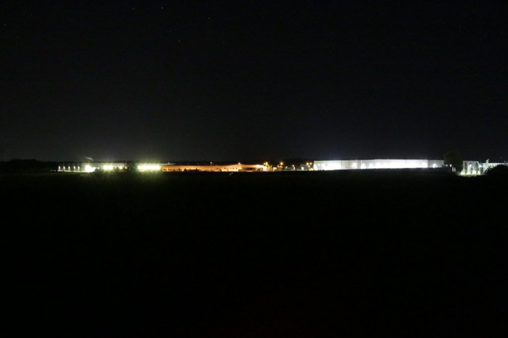 Nachtaufnahme des Gewerbegebietes am Etzberg. Über dem Gebiet ist der Himmel künstlich erhellt, so dass kaum noch Sterne zu sehen sind.